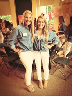 two women standing next to each other in front of a room filled with chairs and tables