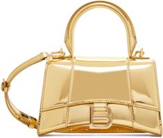 Structured patent calfskin top handle bag in metallic gold tone. · Rolled carry handle · Adjustable and detachable crossbody strap · Patch pocket at back face · Curved base · Logo hardware at foldover flap · Nappa lambskin lining · Logo-engraved gold-tone hardware · H4.5 x W7.25 x D2.5 Supplier color: Gold Gold Balenciaga Bag, Gold Designer Bag, Balenciaga Hourglass Bag, Balenciaga Tote Bag, Balenciaga Purse, Hourglass Bag, Balenciaga Tote, Gold Bodies, Girly Bags