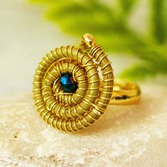 Laura Villalvazo in Mexico creates intriguing jewelry using pine needles gathered from the forest floors of Jalisco. In this unique cocktail ring the pine needles are woven into a tight spiral that is centered by an iridescent teal crystal bead. The spiral is set on a slender 14k gold plated copper band. Mexico Gift, Unique Cocktails, The Spiral, Leaf Ring, Pine Needles, Buy Gold, Jewelry Packaging, In The Forest, Jewelry Gift Box