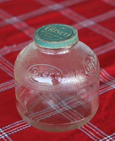 a close up of a water bottle on a red table with a checkered cloth