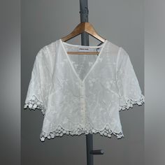 Urban House Embroidered Lace- Trim Blouse Color: White Size: Large Pit To Pit: 19” Shoulder To Hem: 20” Short Sleeve Blouse Featuring Beautiful Embroidered Detailing With Floral Trimmed Edges. New With Tags. Floral Embroidered Short Sleeve Top For Daywear, Elegant Short Sleeve Top With Chikankari Embroidery, Spring Short Sleeve Blouse With Chikankari Embroidery, Embroidered V-neck Blouse For Daywear, Spring Chikankari Embroidered Short Sleeve Blouse, V-neck Floral Embroidery Tops For Daywear, Embroidered V-neck Top For Daywear, Spring Short Sleeve Chikankari Embroidered Top, White V-neck Shirt With Floral Embroidery