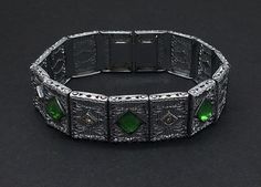 "Antique Art Deco filigree bracelet, wide incorporated in 1896. Filigree links with beautifully engraved. Features 7mm emerald green with bead set crystals The unfoiled green stones are flawless and the hand set crystal chatons show no signs of aging. The rhodium setting is exceptional very clean, with no evidence of any dent, chips or scratches fully functioning measures 7\" long and .75\" width." Victorian Green Bracelets For Gifts, Victorian Green Bracelets As Gift, Victorian Style Green Bracelets For Gifts, Art Deco Green Bracelet For Formal Occasions, Formal Silver Bracelet With Emerald, Art Deco Green Bracelets For Formal Occasions, Formal Silver Emerald Bracelet, Green Art Deco Bracelets For Formal Occasions, Green Art Deco Bracelets As A Gift