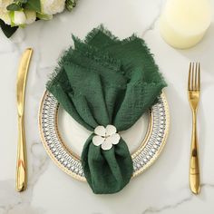 a place setting with green napkins and goldware