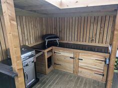 an outdoor kitchen with wood paneling and stainless steel appliances