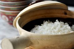 white rice is in a wooden bowl on the table