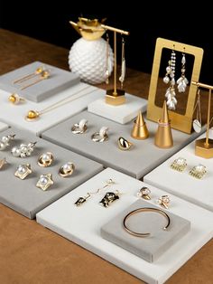 there are many different types of jewelry on the display table, including earrings and rings