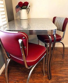 two red chairs and a white table in a room