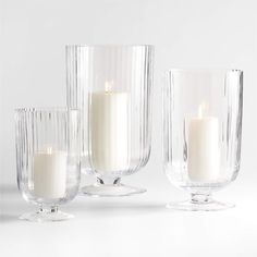 three clear glass vases with candles in them