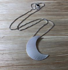 "Featuring the likeness of Stevie Nicks' own sterling silver 1 and 1/4\" crescent moon (20 gauge in thickness). Comes with an 18\" sterling silver box chain. The chain comes with a lobster claw for extra strength and security. The box chain is 1.2 mm thick so it's strong and sturdy. I draw the moon layout on sterling sheet, then pierce and cut the shape, solder the bail on the back so you can wear the moon towards your heart. Finally, I add a final matte finish for a magical and enchanting piece Silver Crescent Necklace With Sun And Moon Design, Silver Moon Necklace For Anniversary, Silver Crescent Moon Charm Jewelry, Silver Moon Necklace With Engraving, Nickel Free Sterling Silver Crescent Necklace, Sterling Silver Moon Engraved Necklace, Sterling Silver Moon Shaped Engraved Necklace, Silver Half Moon Necklaces For Jewelry Making, Engraved Moon Silver Necklace