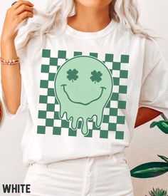 Time to show your Irish pride with this amazing retro St Patrick's Day T-shirt! Featuring a bold design with a retro smiley face on a checkered background, this St Patricks Day tee is perfect for any fan of the holiday. Be the most festively dressed at the Paddy pub crawl and family gatherings! 🍀  Comfort Colors® Lucky Vibes T-shirt, St Patricks Retro Smiley, St Patricks Day T-shirt, Retro Lucky Smile Faces T-shirt, Patrick Day T-shirt SIZE UP for an OVERSIZED FIT (see size chart in listing pho Green Tops With Graphic Design For Fan Merchandise, Smile Faces, Retro Smiley Face, Checkered Background, Irish Pride, Pub Crawl, Bella Canvas Tees, Comfort Colors Tee, Smile Face