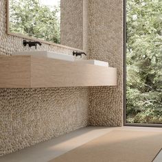 a bathroom with a sink and mirror next to a wall covered in stone tiles,