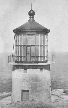 an old black and white photo of a lighthouse