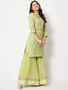 This is a beautiful 3-piece suit set. It comes with straight cut kurta with foil print detailing has 3/4th sleeves, v neck & short length teamed with flared sharara pants and a georgette banarasi dupatta. 3-piece set Color- Pista Green Work- Foil Print Detailing Kurti Length - 36 inch Kurta Fabric-Chanderi Bottom Fabric -Chinon Dupatta Fabric - Georgette Banarasi Dupatta. Sleeves-3/4th Sleeves Neck-V Neck Care - Dry Clean Eid Zari Work V-neck Sets, V-neck Palazzo Set With Zari Work For Eid, Festive V-neck Kurta With Zari Work, Festive V-neck Self Design Kurta, Pista Green Palazzo Set With Gota Work, Festive Palazzo Set With Dupatta, Pista Green Lehenga With Straight Kurta For Ladies, V-neck Palazzo Set With Zari Work For Diwali, Festive Green V-neck Sets