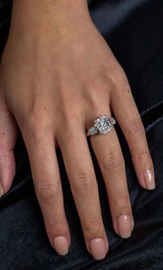 a woman's hand with a diamond ring on it