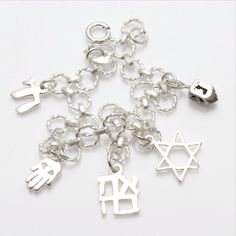 This stunning link bracelet has 5 charms dangling from it. (1) three dimensional dreidel (1) diamond cut star of David (1) Ahava - which means love in Hebrew (1) Hamsa with an evil eye (1) chai. The bracelet is made entirely of sterling silver and has a spring ring clasp. Makes a great Bat Mitzvah gift!!! The bracelet is 7" long. Symbolic Charm Bracelet With Dangling Charms, Silver Symbolic Good Luck Charms, Silver Good Luck Symbolic Charms, Symbolic Dangle Charm Bracelet, Sterling Silver Star Of David Charms Jewelry, Silver Star Of David Jewelry With Charms, Symbolic Sterling Silver Charm Bracelets, Silver Symbolic Bracelets With Dangling Charms, Symbolic Silver Bracelets With Dangling Charms