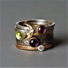 Designer statement stacking ring. Mixed metals of rose gold, yellow gold, white gold, oxidized silver, gold moon, diamond, and gemstones. What's not to love.  This is the most beautiful rustic gemstone stacking ring you will ever see, the ring stack includes five separate rings to wear alone or to stack together. One 9ct gold moon skinny silver blossom ring One Amethyst Wide blossom ring with gold setting One skinny 9ct yellow gold ring and peridot gemstone set in silver One skinny Pink Tourmali Fusion Style Stackable Ring Jewelry, Fusion Style Stackable Round Jewelry, Fusion Style Stackable Round Rings As A Gift, Hammered Round Fusion Jewelry, Fusion Style Hammered Round Jewelry, Fusion Style Stackable Round Rings, Round Hammered Fusion Jewelry, Fine Jewelry Hand Forged Stackable Rings, Unique Hammered Jewelry For Anniversary