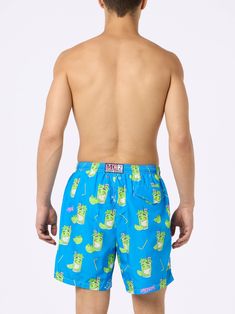 Man Lighting mid-length swim shorts are designed with a lightweight fabric that dries quickly, earning their name Lighting. The elasticized waistband and drawstring closure with branded terminals ensure a comfortable fit, while the branded eyelets are strategically placed to drain water and prevent the shorts from ballooning. Featuring side pockets with French seams and a back patch pocket with a magnetic closure, these swim shorts are both practical and stylish. Additionally, there's a small internal coin pocket for added convenience. The all-over print adds a touch of flair to this versatile swimwear option. The shorts can be neatly folded and stored in the rear pocket when not in use. Crafted from 100% recycled polyester, these shorts reflect our commitment to sustainability. Man Lighti Playful Pool Bottoms With Built-in Shorts, Playful Bottoms With Elastic Waistband For Pool, Playful Cotton Swim Trunks For Pool, Green Cotton Shorts For Pool, Playful Swim Trunks With Elastic Waistband For Poolside, Playful Short Swim Trunks For Swimming, Playful Green Shorts For Poolside, Playful Green Poolside Shorts, Playful Short Bottoms For Poolside