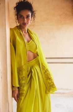 Introducing a breezy and romantic fresh lemon yellow cape set, crafted from pure silk organza fabric for a luxurious feel. This set showcases beautiful scallop and cutwork details, adding an elegant touch to the ensemble. The blouse features draped gathering details, while the pleated pre-draped skirt completes the look with effortless charm. Ideal for adding a touch of sophistication to any occasion. Elegant Yellow Palazzo Set With Traditional Drape, Draped Silk Sets For Summer, Summer Georgette Sets With Cape Sleeves, Summer Sets In Georgette With Cape Sleeves, Summer Sets With Cape Sleeves In Georgette, Yellow Silk Dress With Chikankari Embroidery, Summer Sets With Sheer Dupatta And Cape Sleeves, Yellow Silk Sets For Spring, Yellow Silk Sets With Traditional Drape