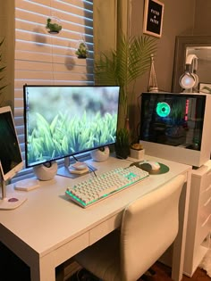 two computer monitors sitting on top of a desk next to a keyboard and monitor screen