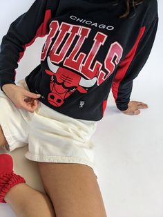 Our absolute favorite Chicago Bulls sweatshirt! Features the classic Chicago Bulls red coloring in the ribbed neckline and inner sleeves. The middle front of the sweatshirt showcases a beautiful print with the Chicago Bulls Logo. The perfect piece to pair with the AGOLDE 90's Pinch Waist Jean. 50% polyester 50% cotton Tag reads Official Licensed Product NBA - Made in USA Recommended for size xs-s, depending on the desired fit. Modeled on a small frame. Please refer to the measurements listed bel Fan Apparel Sweatshirt With Ribbed Cuffs, Fan Apparel Long Sleeve Sweatshirt With Ribbed Cuffs, Sporty Red Sweatshirt For Loungewear, Red Sporty Sweatshirt For Loungewear, Red Sweatshirt With Ribbed Cuffs For Loungewear, Fan Apparel Sweater With Ribbed Cuffs, Fan Apparel Long Sleeve Sweater With Ribbed Cuffs, Long Sleeve Sweater With Ribbed Cuffs For Fans, Red College Sweater With Ribbed Cuffs