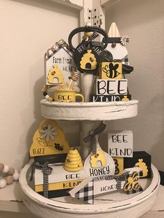 a three tiered cake with bee themed decorations on it's sides and tags hanging from the top