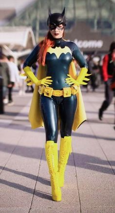 a woman dressed as batgirl walking down the street