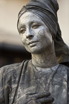 a statue of a woman wearing a turban and holding her hand up to her chest