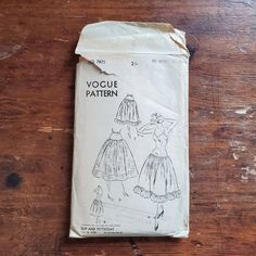 an old fashion sewing pattern on a wooden table