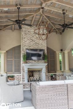 an outdoor living area with couches, chairs and a fireplace