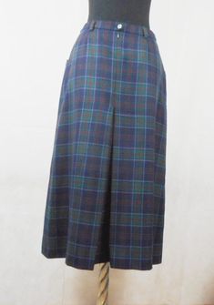 "A real classic vintage garment, beautifully made, elegant skirt by Daks London, plaid in dark blue, green and red. The two side pockets are lined in soft black leather, with full pleat front and back. full lining. This skirt even has small belt loops so you can wear a skinny tan leather belt. This is your perfect Autumn / Winter skirt. Marked: 100% pure new wool, Daks London, size 12 to fit hips 96 cm, made in Great Britain. Condition: in perfectly condition, looks new. Dimensions: Waist: 36cm Tan Leather Belt, Silk Chiffon Scarves, Small Belt, Winter Skirt, Elegant Skirt, Chiffon Scarf, Mid Length Skirts, Wool Skirt, Tank Top Camisole