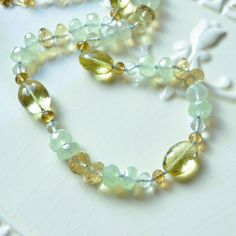 "This luxe gemstone necklace is a stunning piece of jewellery that you will treasure forever. Over four dozen sparkly beads are strung onto light blue silk cord, creating a stunning necklace of subtle colours. A tiny knot separates each stone, which results in a beautiful drape. The stones are about 4mm - 12mm in size, and contain lemon quartz in two shades of yellow, pale green amethyst, rich beer quartz, and mystic green chalcedony. This colour combination is unexpected and so pretty. A small Luxury Adjustable Hand Knotted Necklaces, Handmade Green Citrine Jewelry, Carnelian Earrings, Green Chalcedony, Small Gift Boxes, Silk Cord, Lemon Quartz, Green Amethyst, Colour Combination