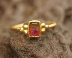 watermelon tourmaline ring, 24k gold ring, 24k gold ring, unique engagement ring, 24k gold gem ring, gold artisan engagement ring, statement ring I love watermelon tourmaline and with this delicate 24k gold setting , it's a refreshing stone breathtaking piece. stone is 6X4.5 mm  watermelon tourmaline I used 24k gold for the setting,  and 22k for the rest of the wire ring (1.4 mm) Please view my full collection of earrings:  https://www.etsy.com/geffenjewelry The jewelry will be packed in a gift Gold Tourmaline Rings, Watermelon Tourmaline Engagement Ring, Gold Ring Unique, Watermelon Tourmaline Ring, Minimal Ring, Bezel Earrings, Wire Ring, Unique Engagement Ring, Dope Jewelry