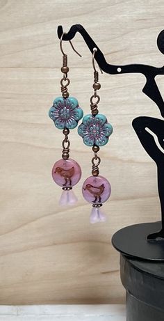 Adorable boho dangle earrings perfect for spring and summer! These are created using Czech glass wild rose flower beads in deep turquoise with a pink wash, Czech glass bird coin beads in shades of pink, and semi-transparent matte pink Czech bell flower beads.  Perfect for everyday, and make a lovely gift!  Total length of earrings, including the ear wire, is approximately 2-1/2".    Thank you for shopping with The Lucie Collection! Whimsical Nickel-free Summer Earrings, Whimsical Nickel-free Earrings For Summer, Bohemian Czech Glass Dangle Flower Earrings, Spring Bohemian Turquoise Jewelry, Bohemian Flower Czech Glass Earrings, Bohemian Flower Earrings With Czech Glass, Bohemian Czech Glass Flower Earrings, Handmade Czech Glass Flower Dangle Earrings, Whimsical Czech Glass Drop Earrings