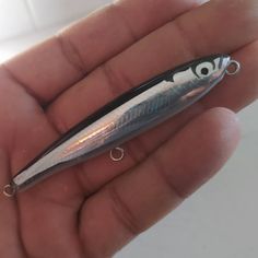 a small fishing lure is held in someone's hand, with eyes on it