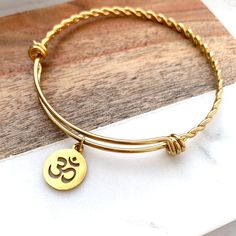 Welcome to buttrescharms! We are newly opened shop and offering the best price for our unique custom bracelets! ❤️This listing is for one OM Bangle bracelet shown above. All the charms and bangle are made of stainless steel. ❤️ You can keep it simple, or you can add birthstone, Initial letter--leave a message about the Size: Small, Medium, Large ❤️We hand pick the best quality charms and beads from around the world to make this bracelet timeless. ❤️ How long until I get my order? We normally shi Spiritual Hypoallergenic Bangle Jewelry, Adjustable Round Spiritual Bangle, Spiritual Round Stainless Steel Bracelets, Adjustable Spiritual Yellow Gold Charm Bracelet, Personalized Spiritual Bangle Bracelet, Spiritual Stackable Charm Bracelet Gift, Spiritual Hypoallergenic Bracelets For Personalized Gifts, Spiritual Nickel-free Bangle Charm Bracelet, Nickel-free Spiritual Bangle Charm Bracelet