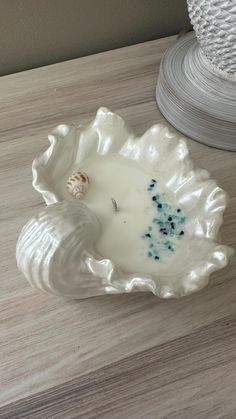 a white candle sitting on top of a wooden table