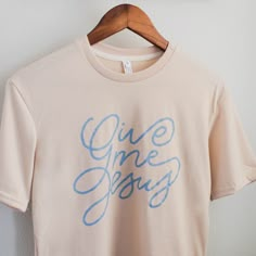 Infuse your faith into your everyday style with our Give Me Jesus Tee. Made from an extremely soft polyester-spandex blend, this cream shirt features a beautiful script design by the Daily Grace Co. team. Inspired by a beloved hymn, it's a great reminder to keep your focus on Jesus. Want to know if this will fit? Check our sizing chart! Church Merch Ideas, Trending T Shirt Designs, Trendy Tshirt Designs, Mom Shirt Designs, Graphic Tees Design Prints, Jesus Shirts Women, Jesus Merch, Church Merch, Daily Grace Co