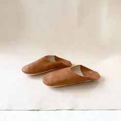 These natural leather Moroccan slippers have been skillfully handmade by our artisans. The buttery soft leather of each slipper molds perfectly to the shape of your foot, meaning slipping into a pair after a long day will feel like bliss. Both super stylish and sumptuously soft, these beauties are sure to add the perfect touch of chic to your loungewear wardrobe. Indoor use only. XS is Approximately 9.5" long (EU 37-38)S is Approximately 10" long (EU 38-39)M is Approximately 10.5" long (EU 40-41 Loungewear Wardrobe, Moroccan Slippers, Babouche Slippers, Artist Branding, Vintage Textiles, East London, Natural Leather, Soft Leather, Lounge Wear