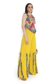 Yellow and multi color sleeveless back tie-up choli with all over bohemian tribe vibe embroidery and tassel embellishments. Paired with a mukaish dot embroidered sharara with tassel detailing. - Aza Fashions Multicolor Georgette Palazzo Set For Summer, Bohemian Designer Wear Sets In Multicolor, Bohemian Designer Multicolor Sets, Bohemian Multicolor Embroidered Palazzo Set, Bohemian Embroidered Multicolor Palazzo Set, Multicolor Palazzo Set With Gota Work Traditional Drape, Multicolor Bohemian Georgette Sharara, Yellow Bohemian Palazzo Set With Dupatta, Bohemian Sleeveless Sharara For Diwali