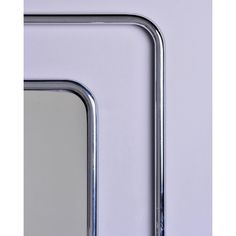 a close up of a metal frame on a wall with a mirror in the middle