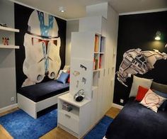 two beds in a room with black walls and blue carpet