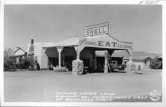 an old black and white photo of a gas station