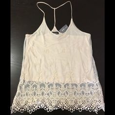 Ivory Double-Layered Camisole. Bottom Layer Is Cotton For Coverage While Top Layer Is Sheer With 3d Design Lace Embroidery. 2 Straps On Shoulders Combine Behind Neck Into 1 Strap For A Racer Back Style. This Versatile Top Can Easily Be Dressed Up Or Down For A Night Out For A Delicate Look Or A Casual Day And Still Look Cute! Brand New With Tag! (Tag Price Torn) Non-Smoking/Pet-Free Home. Sheer Lace Camisole Top, Chic Lace Tank Top For Spring, Spring Lace Cami Top, Summer Lace Camisole With Lace Top, Lace Cami Top For Summer, White Lace Trim Tank Top For Party, Chic Lace Camisole For Summer, Feminine Cream Tank Top For Spring, Feminine Sheer Camisole Top