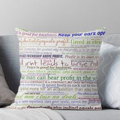 a pillow on a couch that has words written in different colors and font, including the word