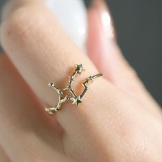 a close up of a person's hand wearing a ring with stars on it