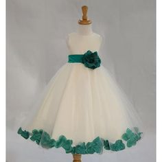 a white and green flower girl dress on a mannequin