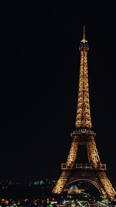 the eiffel tower lit up at night with lights on it's sides