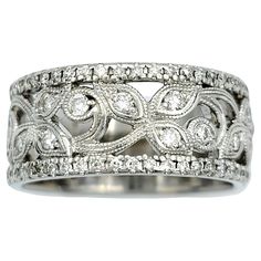 a white gold ring with diamonds in the middle and an intricate design on it's side