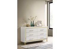 a white and gold dresser with flowers on top