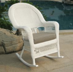 a white rocking chair next to a pool